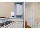 Bright kitchen area with a double sink, white cabinets and modern dishwasher at 1208 Copper Creek Dr, Durham, NC 27713