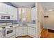 White kitchen with stainless sink, white appliances and view of breakfast nook at 1208 Copper Creek Dr, Durham, NC 27713