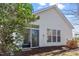 Home's rear exterior with sliding glass door and views of the natural backyard at 1208 Copper Creek Dr, Durham, NC 27713