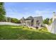 Backyard view showcases a lovely patio area, outdoor dining furniture, and a well-manicured lawn for entertainment at 121 Talley Ridge Dr, Holly Springs, NC 27540