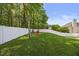 Expansive backyard with a pristine white fence, mature trees, and a cozy seating area for relaxing outdoors at 121 Talley Ridge Dr, Holly Springs, NC 27540