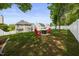 Spacious backyard with lush green grass, privacy fence, and a charming fire pit area perfect for entertaining at 121 Talley Ridge Dr, Holly Springs, NC 27540