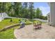Landscaped backyard with patio, grill, dining furniture, and stepped access to upper yard at 121 Talley Ridge Dr, Holly Springs, NC 27540