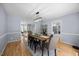Formal dining room features modern chandelier, wood floors, and french doors to office space at 121 Talley Ridge Dr, Holly Springs, NC 27540