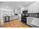 Bright kitchen featuring stainless steel appliances, white cabinets, and a stylish gray backsplash at 121 Talley Ridge Dr, Holly Springs, NC 27540