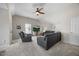 Comfortable living room features neutral carpet, ceiling fan, and a leather sectional with recliner at 121 Talley Ridge Dr, Holly Springs, NC 27540