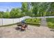 Stone patio features a grill, table, and chairs; stone steps lead to the upper yard at 121 Talley Ridge Dr, Holly Springs, NC 27540