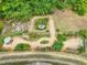 Aerial view of a meticulously landscaped yard with winding pathways, lush greenery, and various seating areas at 123 Beech Forest Way, Pittsboro, NC 27312