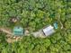 Aerial view of a secluded property featuring two buildings, a swimming pool, and surrounded by lush trees at 123 Beech Forest Way, Pittsboro, NC 27312