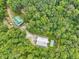Aerial view of a secluded property featuring two buildings, a swimming pool, and surrounded by lush trees at 123 Beech Forest Way, Pittsboro, NC 27312
