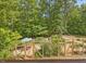 Backyard area with umbrella-covered seating, landscaping, and fencing at 123 Beech Forest Way, Pittsboro, NC 27312