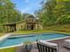 Stunning backyard featuring a sparkling pool and a charming home with a balcony overlooking the serene landscape at 123 Beech Forest Way, Pittsboro, NC 27312