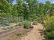 Backyard area with gravel path, landscaping, and fencing at 123 Beech Forest Way, Pittsboro, NC 27312
