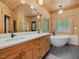 Spa-like bathroom with a soaking tub, double vanity, and natural wood accents at 123 Beech Forest Way, Pittsboro, NC 27312