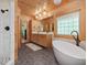Spacious primary bath boasting double vanity, soaking tub, and tiled shower, all in a wood paneled setting at 123 Beech Forest Way, Pittsboro, NC 27312