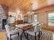 Inviting dining area with a stone fireplace, wood accents, and modern chandelier at 123 Beech Forest Way, Pittsboro, NC 27312