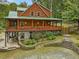 Log home featuring a porch, tiered landscaping with stone walls, and a natural setting at 123 Beech Forest Way, Pittsboro, NC 27312