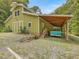 Exterior of a home with a large garage and a vintage green truck parked under a covered area at 123 Beech Forest Way, Pittsboro, NC 27312