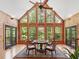 Bright living room featuring a vaulted ceiling, many windows, and wooden walls at 123 Beech Forest Way, Pittsboro, NC 27312