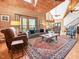 The spacious living room boasts wood paneling, windows, natural light, and plush seating at 123 Beech Forest Way, Pittsboro, NC 27312