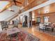 Living room featuring wood paneling, natural light, stairs, and a stone fireplace, leading into dining area at 123 Beech Forest Way, Pittsboro, NC 27312