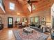 Living room featuring wood paneling, windows, natural light, plush seating, and hardwood floors at 123 Beech Forest Way, Pittsboro, NC 27312