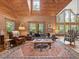 Living room featuring wood paneling, windows, natural light, plush seating, and access to the balcony at 123 Beech Forest Way, Pittsboro, NC 27312