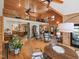 Open-concept living room boasts wood paneling, vaulted ceiling, fireplace, and access to kitchen and dining area at 123 Beech Forest Way, Pittsboro, NC 27312