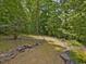 Scenic property showcasing a wooded path winding through lush greenery and natural rock borders at 123 Beech Forest Way, Pittsboro, NC 27312