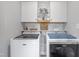 Well-lit laundry room with a washer, dryer, cabinets, and decorative accents at 123 Hawick Ct, Zebulon, NC 27597