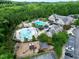 Aerial view of a community pool, playground, and clubhouse surrounded by lush greenery and parking at 1241 Keith Rd, Wake Forest, NC 27587