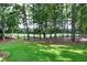 Expansive backyard featuring lush lawn and mature trees, overlooking the golf course at 1241 Keith Rd, Wake Forest, NC 27587