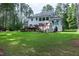 Manicured backyard showcases lush green grass, a stone fireplace, and a charming deck at 1241 Keith Rd, Wake Forest, NC 27587