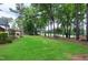 Lush backyard with a fireplace and pergola, bordering a picturesque golf course and surrounded by tall trees at 1241 Keith Rd, Wake Forest, NC 27587
