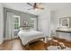 Cozy bedroom with hardwood floors, a ceiling fan, and two bright windows at 1241 Keith Rd, Wake Forest, NC 27587