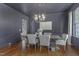 Elegant dining room with dark blue walls, hardwood floors, modern chandelier, and seating for six at 1241 Keith Rd, Wake Forest, NC 27587