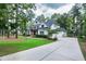 Lovely two-story white home with long driveway and three car garage surrounded by lush landscaping at 1241 Keith Rd, Wake Forest, NC 27587