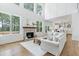 Bright living room with fireplace, large windows, hardwood floors, and open layout to the kitchen at 1241 Keith Rd, Wake Forest, NC 27587