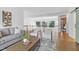 Open living area with hardwood floors, gray sofa, white chairs, and view to additional living space at 1241 Keith Rd, Wake Forest, NC 27587