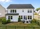 Spacious backyard featuring a well-maintained lawn, patio with seating, and a black fence at 128 Highland Grove Way, Fuquay Varina, NC 27526