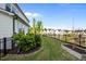 Well-maintained backyard with a spacious lawn, black fencing, and garden bed at 128 Highland Grove Way, Fuquay Varina, NC 27526