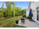 Relaxing backyard with patio seating, a manicured lawn, and beautiful tree line views at 128 Highland Grove Way, Fuquay Varina, NC 27526