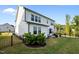 Picturesque backyard with a green lawn, patio seating area, and enclosed by a sleek black fence at 128 Highland Grove Way, Fuquay Varina, NC 27526
