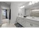 Elegant bathroom with double sinks, neutral decor, and a view to an adjacent room at 128 Highland Grove Way, Fuquay Varina, NC 27526
