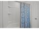 Clean bathroom with a shower/tub combo featuring white tile and a patterned shower curtain at 128 Highland Grove Way, Fuquay Varina, NC 27526