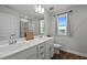 Bright bathroom featuring a double vanity, framed mirror, and natural light from a window at 128 Highland Grove Way, Fuquay Varina, NC 27526