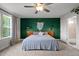 Stylish bedroom with a green accent wall, modern lighting, and ceiling fan for added comfort at 128 Highland Grove Way, Fuquay Varina, NC 27526