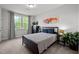 Cozy bedroom with a large window, a dresser, two side tables, and neutral decor at 128 Highland Grove Way, Fuquay Varina, NC 27526