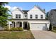 Charming two-story home with a white exterior, front porch, and well-maintained lawn and landscaping at 128 Highland Grove Way, Fuquay Varina, NC 27526