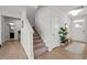 Entryway with carpeted stairs, wood floors, and a stylish rug and greenery accentuating the entrance at 128 Highland Grove Way, Fuquay Varina, NC 27526